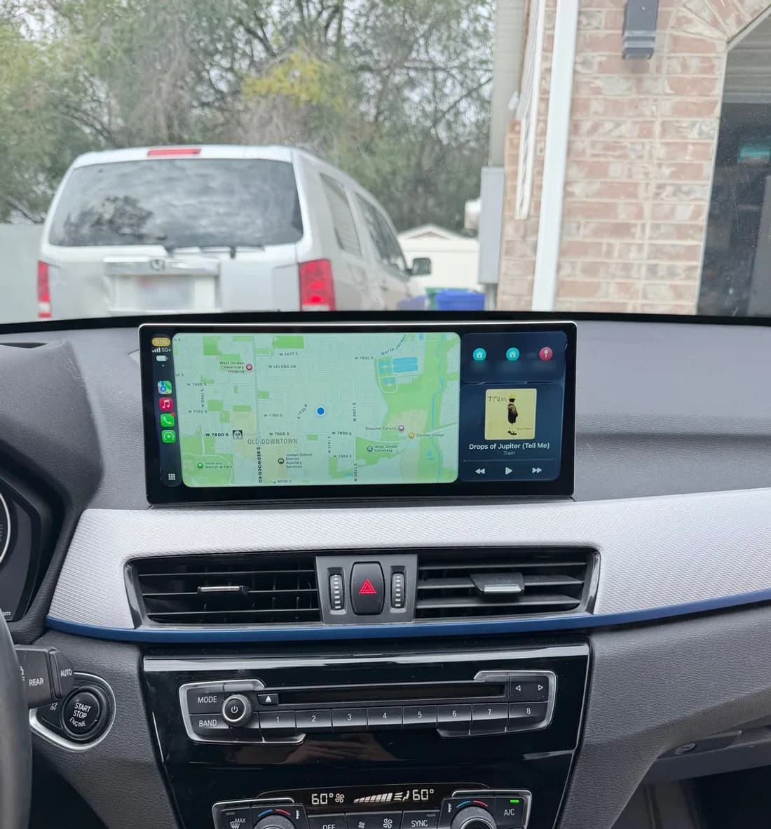 Widescreen Apple CarPlay display with maps and music installed in a BMW dashboard